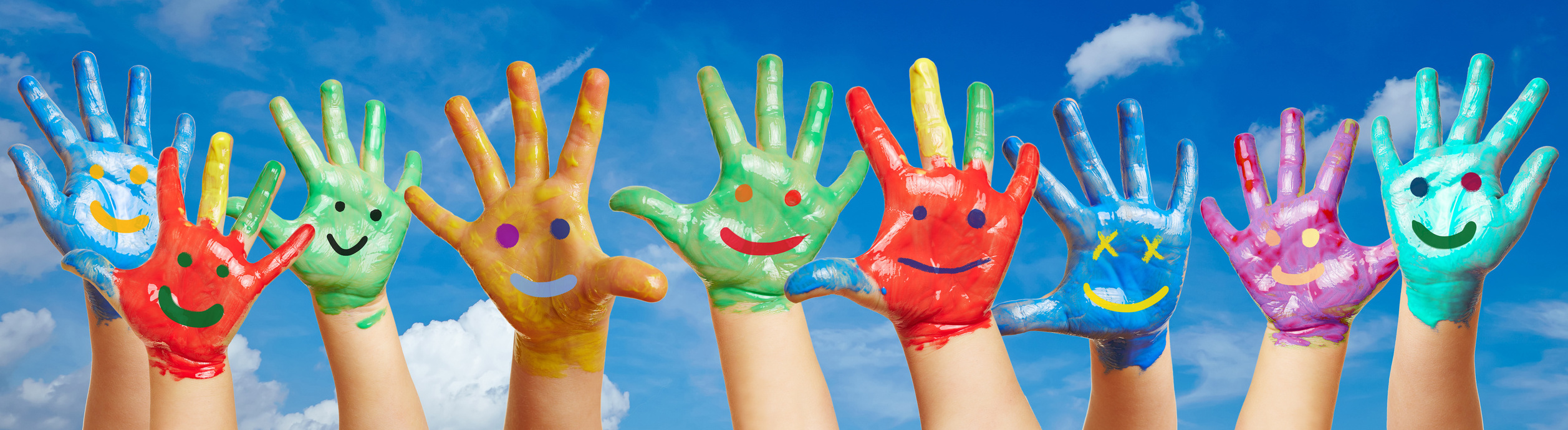 Viele bunte Kinderhände vor Himmel Viele bunte Kinderhände vor Himmel